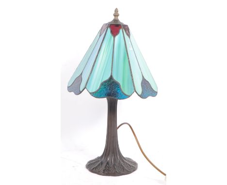 A mid 20th century Art Nouveau manner bronze Tiffany style table lamp. Having a fluted, tapered base, with leaf shaped deatil