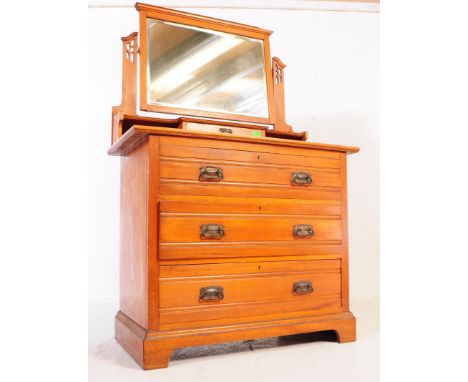 An Edwardian Art Nouveau influence walnut drop centre dressing table chest of drawers. Raised on plinth base with triple draw