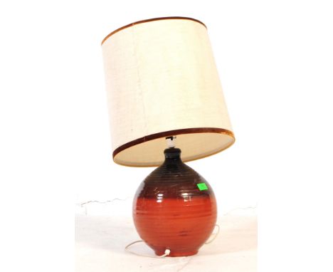 A mid 20th century West German manner terracotta ceramic lamp. The lamp having a bulbous base with a terracotta coloured grou