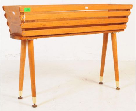 A vintage mid 20th century circa 1950s teak wood planter trough on feet. The tough having a squared form raised on tapering d