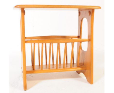 ERCOL - A late 20th century Ercol beech wood magazine rack / table in the Chaucer range / pattern. Raised on pierced shaped s