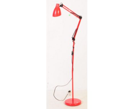 A contemporary floor standing anglepoise standard lamp. The lamp having a round weighted base, red colourway, with thin centr