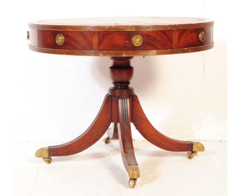 A 20th century George III revival low mahogany drum /rent table. The table having a round top, with drawers surrounding, each