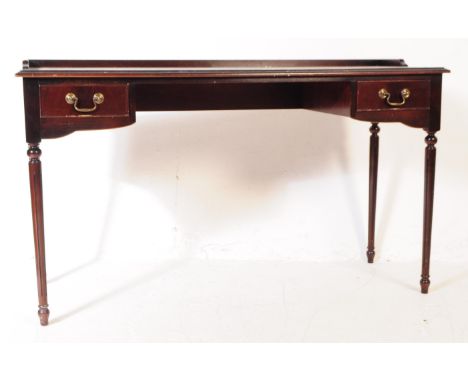 A George III Revival ebonised mahogany writing table desk. The table having a central skiver with a chamfered edge top surrou