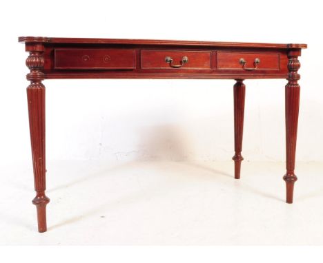 A Regency George III revival mahogany library / writing table desk. Raised on turned round tapered legs. Triple drawers to th