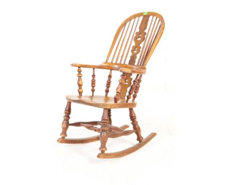 A 19th century elm wood smokers bow rocker / rocking chair. With comb / stick back backrest and bowed top rail, saddle seat a