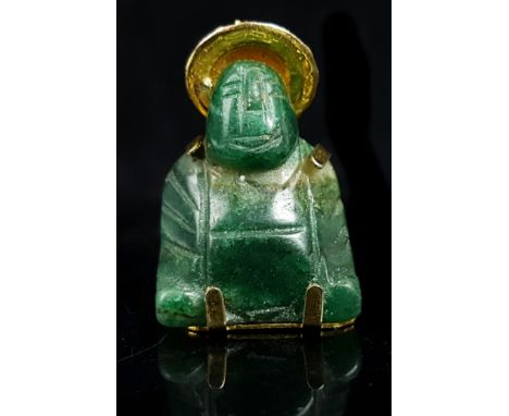 A carved spinach jade pendant in the form of a seated Buddha, yellow metal mounted with hat and character mark, the hat set w