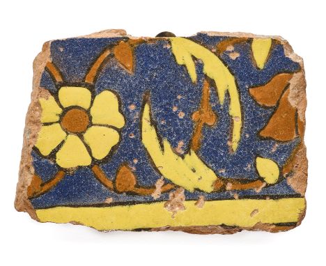 A MUGHAL CUERDA SECA BORDER TILE FRAGMENT, PUNJAB, MID-17TH CENTURY glazed red earthenware, decorated with scrolling yellow a