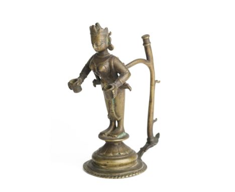 A BRONZE LAMP HOLDER, ORISSA, CIRCA 18TH CENTURY in the form of a female deity on flared circular base, wearing disc earrings