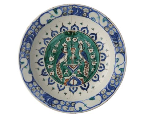 AN IZNIK DISH, OTTOMAN ANATOLIA, CIRCA 1590-1600 underglaze painted fritware, the well decorated with a green ground roundel 