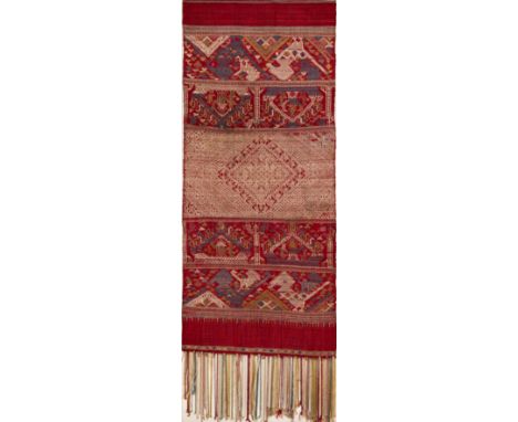A WOVEN SILK SASH, LAOS, 19TH/20TH CENTURY of rectangular form, the crimson ground decorated with polychrome registers of geo