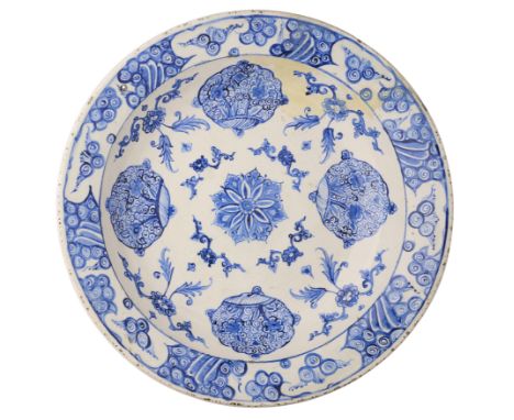 AN IZNIK BLUE AND WHITE DISH, OTTOMAN ANATOLIA, CIRCA 1560-80 underglaze painted fritware, decorated with central floral rose