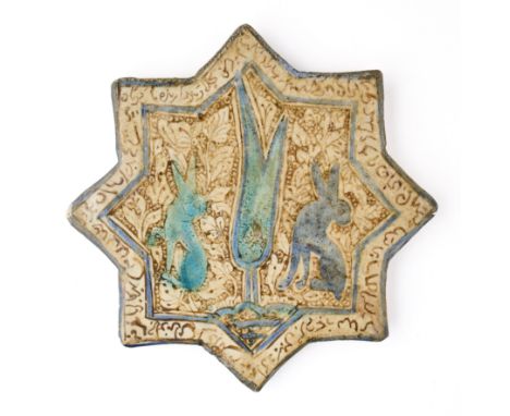 A KASHAN LUSTRE STAR TILE, PERSIA, 13TH CENTURY glazed fritware, depicting a pair of rabbits beside a cypress tree, amidst de