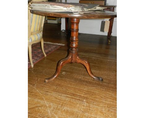 A late George III mahogany tilt-top tea table, raised on a baluster turned column support tripod base with slipper feet. D.84