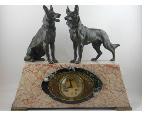 An Art Deco marble mantle clock, having two spelter German shepherds mounted to top, having a round brass dial with Arabic nu