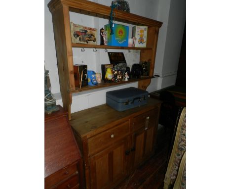 An early 20th century pine high back kitchen dresser, having a two shelf upper section above two drawers and two cupboard doo