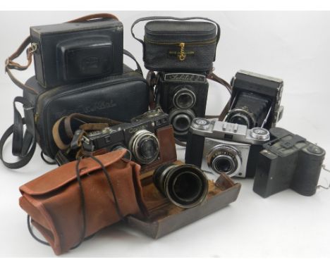 A collection of cameras, to include a Zeiss Ikon folding camera, an Ikomatic A, a Karl Zeiss Sonnar 1:4 lens, and an Ernst Le