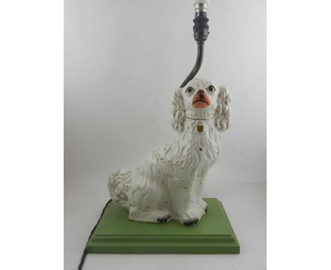 A 19th century Staffordshire ceramic dog, mounted on to a green stepped base and converted into a lamp. H.58cm