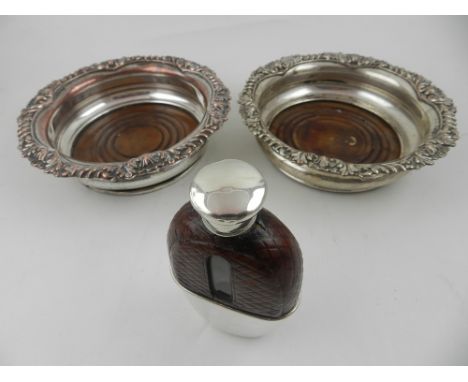 A pair of silver plated wine coasters, together with a hip flask, having silver lid. (3)