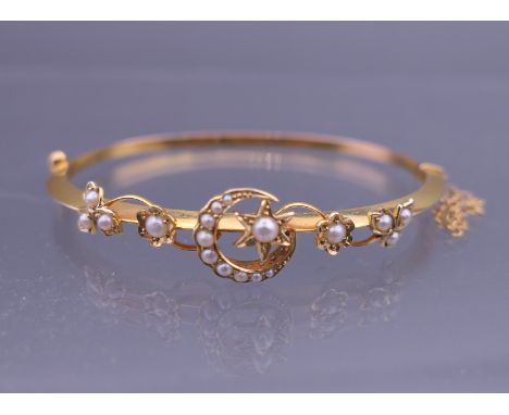 A gold seed pearl set bangle form bracelet. 6.25 cm wide. 7.1 grammes total weight.