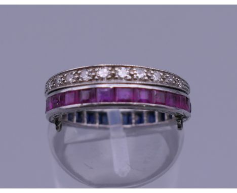 An unmarked white gold diamond, ruby and sapphire ring. Ring size J/K. 