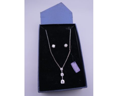 A boxed silver dress pendant on chain and matching earrings. The pendant 2.5 cm high.