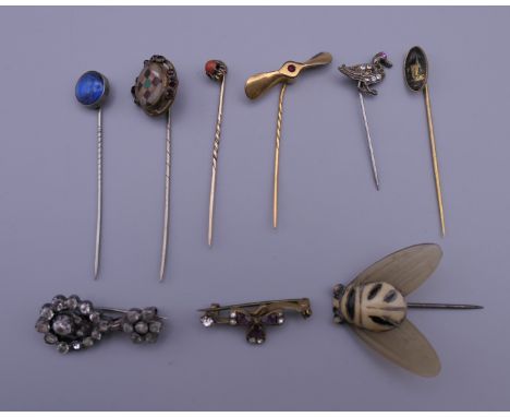 A collection of stick pins and brooches. 