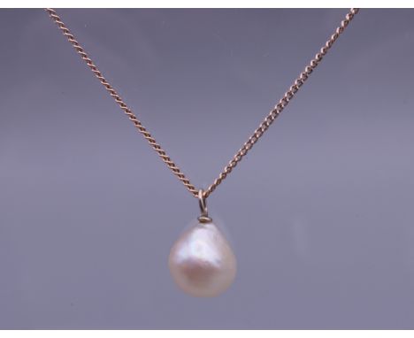 A pearl pendant on a 9 ct gold chain. The pearl approximately 9 mm high. 