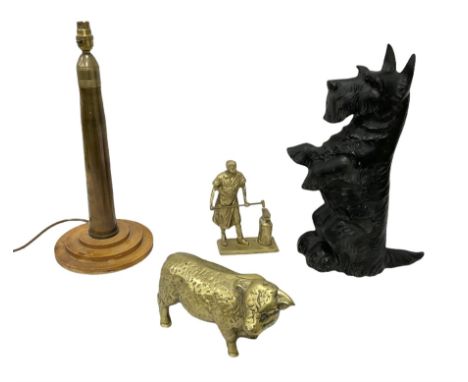 Cast iron doorstop modelled as a Scottie dog, brass model of a bull, brass model of a blacksmith and a brass shell converted 