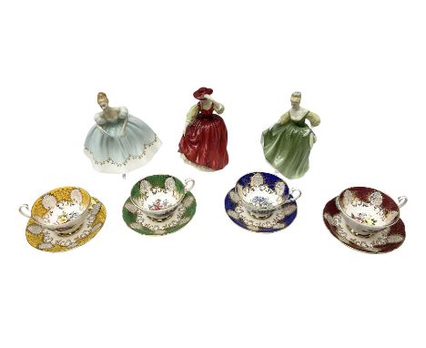 Four Paragon tea cups and saucers with gilt and floral decoration in various colours, together with three Royal Doulton figur