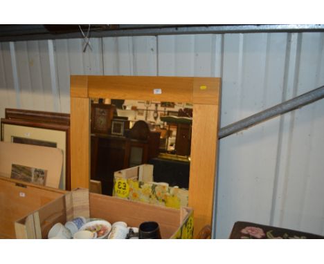 A light oak framed wall mirror