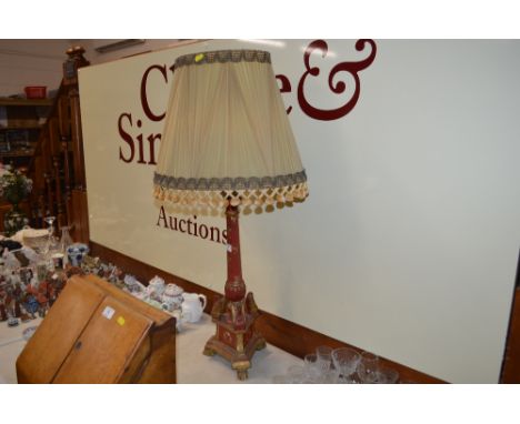 A carved wooden table lamp and shade with red and gilt painted decoration