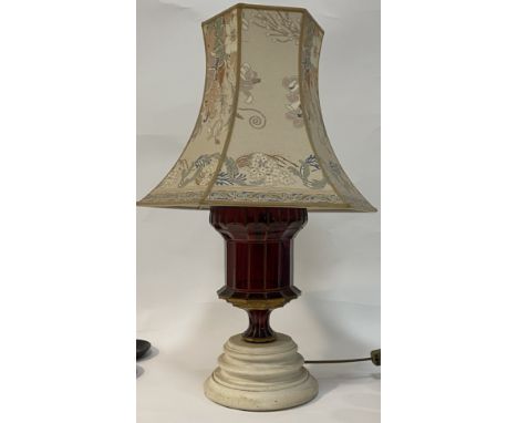 A gilt painted ruby glass table lamp, fitted with two branches and raised on a turned base, complete with decorative shade. H