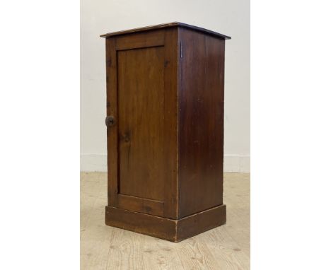 A Victorian stained pine bedside cupboard, the panelled door opening to a shelf behind, raised on a skirted base. H80cm, W40c