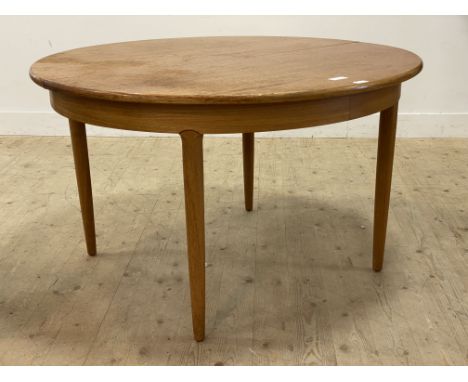 A mid century teak circular dining table with magic leaf to centre and raised on turned and tapered supports (a/f) H73cm, 170