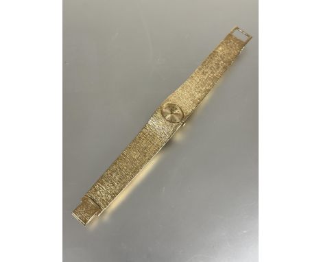 A ladys 9ct gold Bueche -Girod vintage 1960s wristwatch with oval gilt dial and baton hour markers on textured articulated li