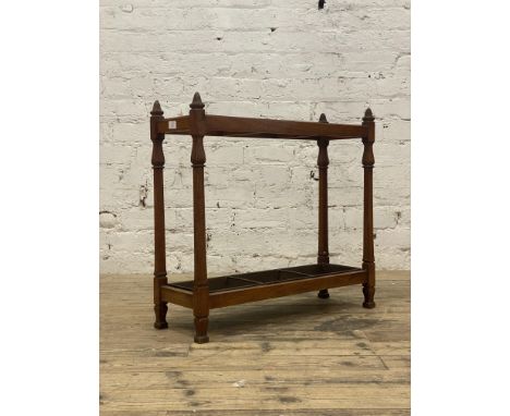 An early 20th century walnut stick stand, two divisions and complete with drip tray. H68cm, L71cm.&nbsp;