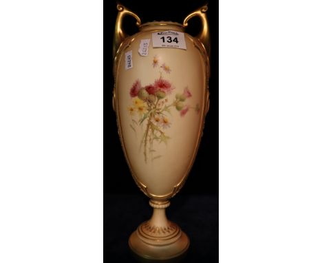 Royal Worcester peach ground urn shaped pedestal vase with hand painted floral decoration and over gilding. Printed marks to 