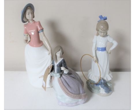 A Lladro figure of a lady in flowing dress (a/f) together with two Nao figures of a girl with a hoop and a girl with flower 