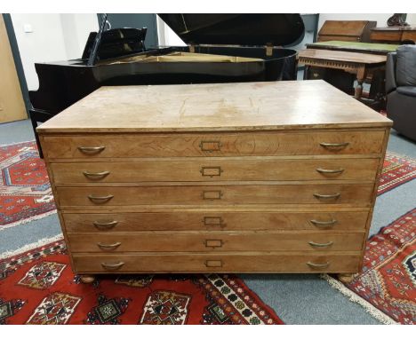 An early 20th century oak six drawer plan chest, width 145cm CONDITION REPORT: See additional images. Some small losses to th