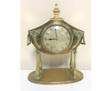 A French brass Art Nouveau mantel clock on raised legs, with key
