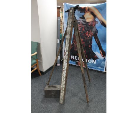 A vintage lacquered theodolite signed Hall Bros. Croydon, with tripod and yardstick 