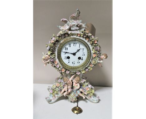 A Meissen four seasons china mantel clock encrusted with flower and cherub decoration with pendulum   CONDITION REPORT: Some 