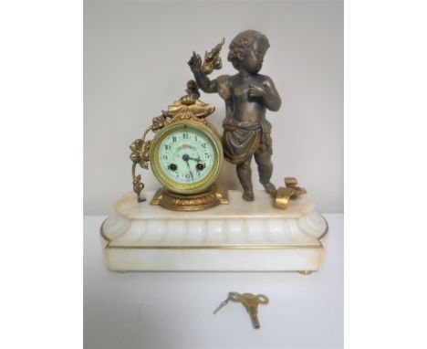A continental gilt figural mantel clock of a cherub with enamelled dial on marble base 