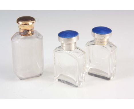 A PAIR OF SILVER ENAMEL TOPPED BOTTLES and a spring-loaded silver gilt topped bottle 8.5cm high