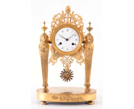 AN EARLY 19th CENTURY FRENCH ORMOLU MANTEL CLOCK having a fretwork surround supported by two Egyptian figures standing an ova