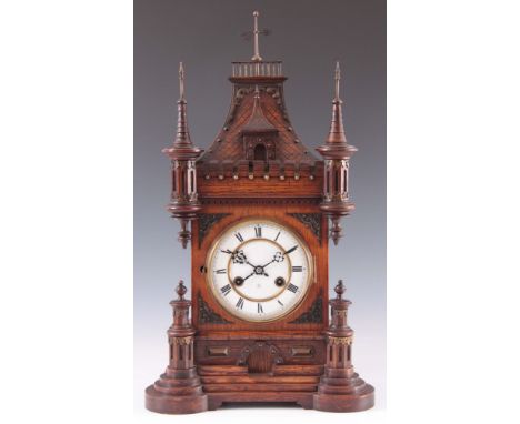 A LATE 19th CENTURY GERMAN OAK CASED MANTEL CLOCK the architectural style case surmounted by turrets and a weather vane enclo
