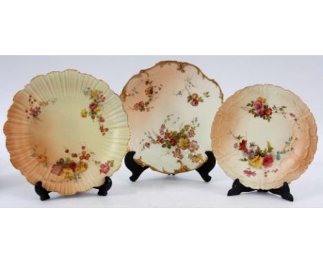 THREE DECORATIVE ROYAL WORCESTER BLUSHED IVORY CABINET PLATES with shaped gilt rimmed borders enclosing painted sprays of sum