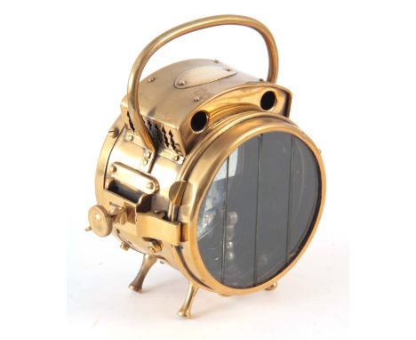 A BRASS POLKEY HEADLAMP with loop handle 22cm high