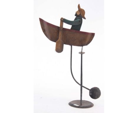 A FOLK ART PAINTED STEEL AUTOMATON ROWING BOAT, balance toy with sailor rowing 44cm high by 30cm wide.